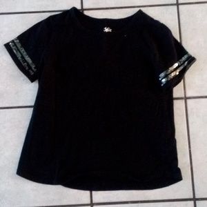 A black shirt sparkles around the sleeve